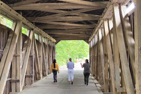 Design interns walking through one of Flemingsburg's many covered bridges
