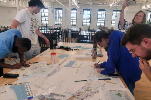 Design interns working on design plans for Maysville KY, standing around a work table