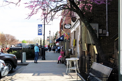 People walk downtown on a sidewalk